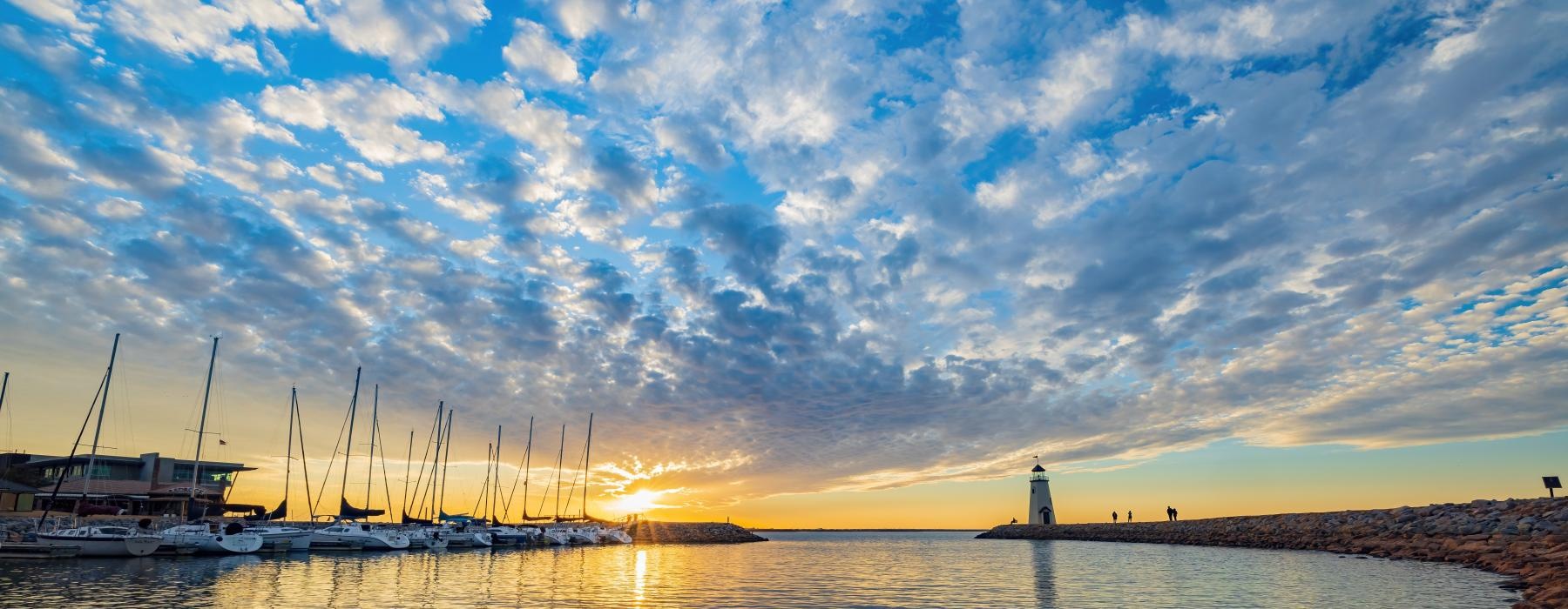 a body of water with boats in it and a sunset in the background